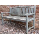 A painted and weathered teak garden bench with slatted seat and oval slatted back, 150 cm long