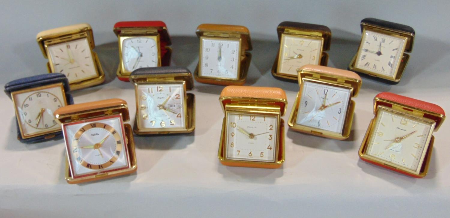 A collection of eleven various leather cased folding travel alarm clocks by HAC, Westclox and others