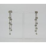 Pair of articulated 18ct white gold drop earrings set with graduated diamonds, largest pair of