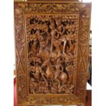 A deeply carved Taiwanese panel in hardwood, showing characters amongst forest glade, within a