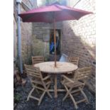 A good quality contemporary teak garden table of circular form with segmented and slatted top raised