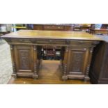 An oak kneehole desk with all round carving, fitted with three frieze drawers, the pedestal