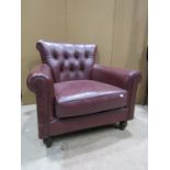 A contemporary drawing room chair with buttonback and loose cushion, upholstered in a mid