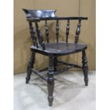 A dark stained Windsor smokers bow chair in elm and beechwood with turned spindle back