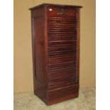 An Edwardian mahogany pedestal filing cabinet enclosed by a rise and fall tambour door with ten