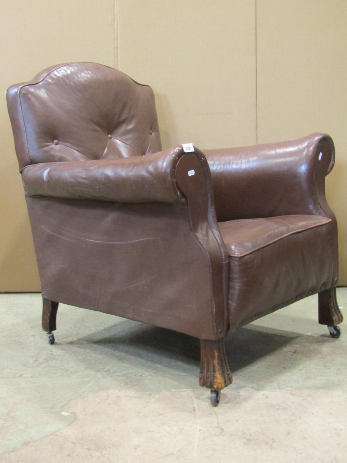 An early 20th century easy chair in the traditional style with rolled arms and shaped back, faux