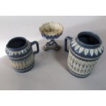 Two Doulton Lambeth graduated blue ground jugs with moulded lozenge and flower head detail in