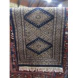 A small oriental rug with twin medallion centre in several repeating borders, 65 x 95 cm approx