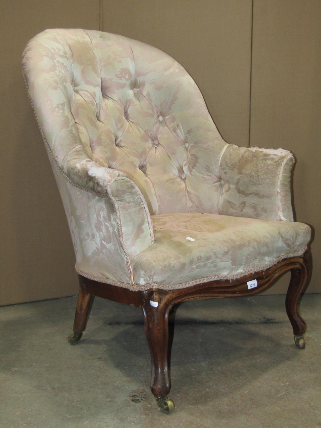 A mid-Victorian period drawing room chair with deep button back, serpentine seat and raised on a