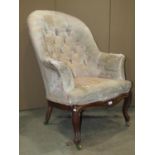 A mid-Victorian period drawing room chair with deep button back, serpentine seat and raised on a