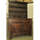 An 18th century oak dresser, the base enclosed by a pair of moulded panelled doors beneath two