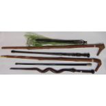 A collection of walking sticks to include two hazel example with hand worked mounts, two African