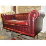A traditional Victorian style Chesterfield sofa with deep buttoned back, upholstered in an ox red