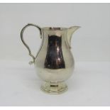 A good quality Georgian style cream jug, the body of baluster form with scrolled handle and