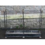 A vintage iron work umbrella stand of rectangular form with interlocking rod frame and faceted