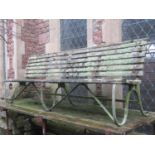 A sprung steel park/garden bench with weathered timber lathes and green painted finish, 8ft long