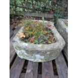 A weathered natural stone trough of rectangular form with single rounded end, 72 cm long x 46 cm