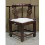 A Georgian walnut corner chair with pierced vase shaped gothic tracery splats over a drop in