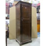 An Edwardian sentry box hall robe enclosed by a full length twin panelled door raised on bracket