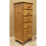 A modern Victorian style stripped pine pedestal chest of six drawers raised on turned bun feet, 45