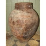 An old terracotta oviform jar with simple incised banded detail 56 cm high