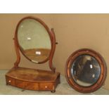 A Georgian mahogany toilet mirror, the oval mirror plate raised on shaped supports, the box base