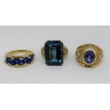 Three 9ct blue gemstone dress rings; a sapphire and diamond cluster half hoop ring, a topaz and