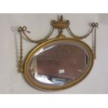 A small Georgian style gilt framed wall mirror of oval form with bevelled edge plate, within a