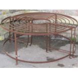 An old ironwork two sectional tree seat with strap and rod framework approx 4ft in diameter