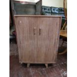 Heal's style limed oak cupboard, fitted with two hinged doors upon splayed bracket feet, 117cm