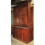 A stained pine dresser/side cabinet in two sections, the upper slightly recessed and enclosed by a