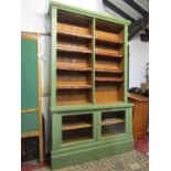 A library bookcase with green painted finish, in two sections, the lower enclosed by a pair of