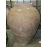 An old terracotta oviform jar with simple incised detail, 58 cm high