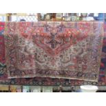 A large Persian wool carpet with red field and white ground outer borders and busy repeating running