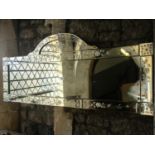 A Venetian style wall mirror of slender rectangular and arched form, the segmented marginal surround