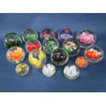 A large collection of novelty paperweights all inset with floral or botanical decorations (16)