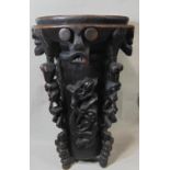 A substantial carved African timber mortar of cylindrical form raised on four turned and carved