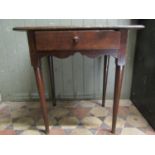 A Georgian oak side table with rectangular overhanging boarded top over a frieze drawer with