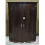 19th century oak bow fronted hanging corner cupboard with exposed brass H shaped hinges and