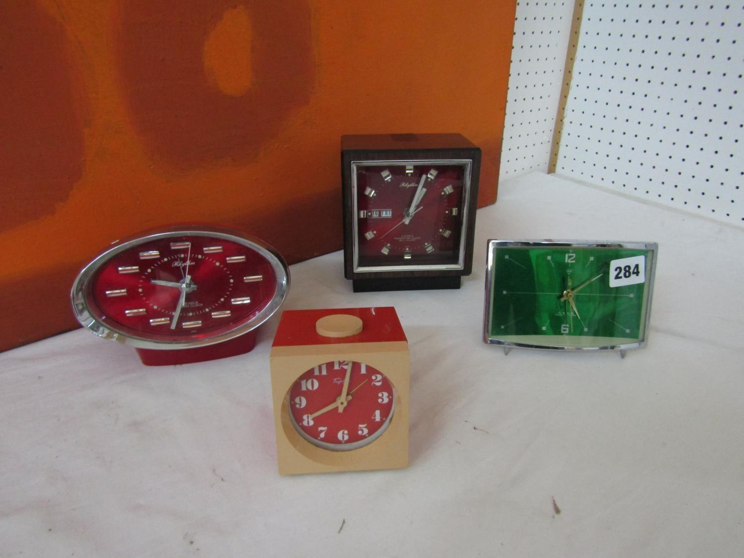 A collection of retro alarm clocks to include a Rhythm four jewel transition bell clock with day