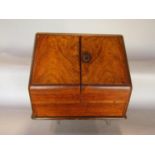A Victorian walnut and figured walnut sloping stationery cabinet with segmented interior