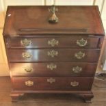 A Georgian mahogany bureau, the fall flap enclosing a fitted interior of small drawers, pigeon holes