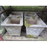 A set of four weathered cast composition stone garden planters of square tapered form with simulated