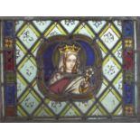 A 19th century leaded and stained glass panel depicting the Virgin holding a lily, within floral and