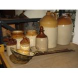 A small collection of stoneware jars and flagons together with four antique brass and steel skimmers