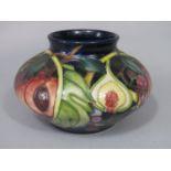 A Moorcroft vase of squat circular form with moulded and painted fruit detail, including grapes,