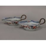 A pair of early 19th century oriental Imari sauce boats with painted and gilded decoration to the