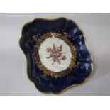 An 18th century Worcester dish of square shaped form with central painted floral panel within blue