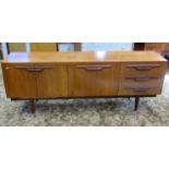 A long and low retro teak sideboard, partially enclosed by three doors and a tower of three drawers,