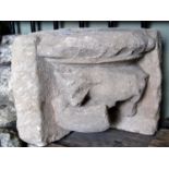 An antique possibly early reclaimed carved natural stone corbel/corner stone with bull and shield